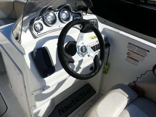 Slide: The Image of 2016 NauticStar 203 DC boat dashboard with steering wheel and gauges. - 9
