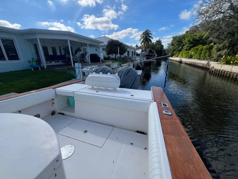 Slide: The Image of 2008 Regulator 32 FS boat docked by a canal, surrounded by houses and lush greenery. - 13