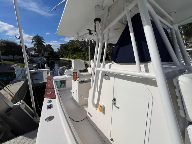 Slide: The Image of 2008 Regulator 32 FS boat docked, featuring spacious deck and seating under clear skies. - 16