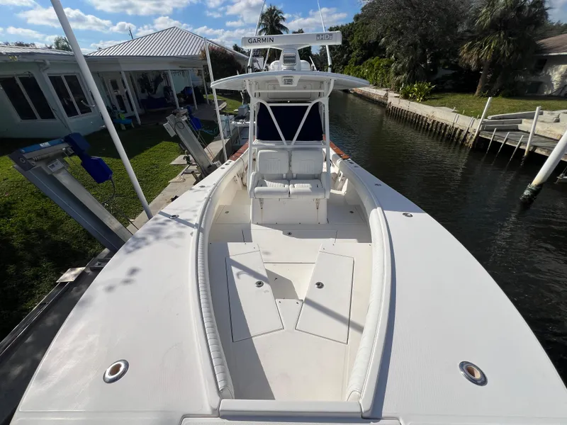 Slide: The Image of 2008 Regulator 32 FS boat docked by a canal, featuring spacious deck and seating. - 7