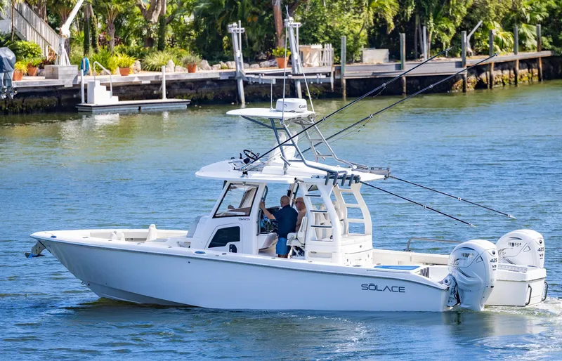 Slide: The Image of 2021 Solace 345 boat cruising on a serene waterway with lush greenery. - 0