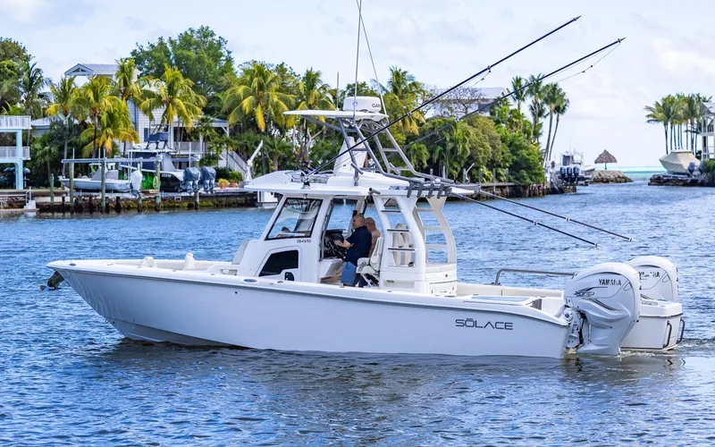 Slide: The Image of 2021 Solace 345 boat cruising on a tropical waterway with palm trees in the background. - 1