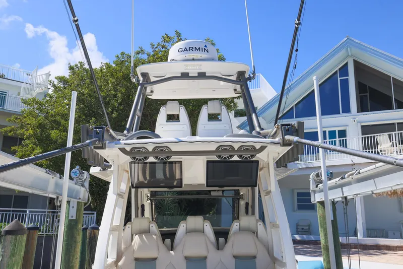 Slide: The Image of 2021 Solace 345 boat docked near modern waterfront home, featuring advanced Garmin equipment. - 20