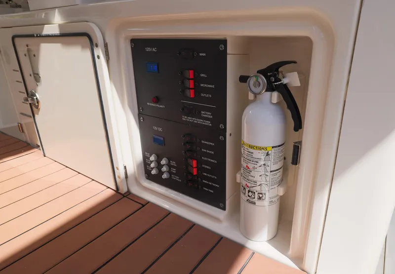 Slide: The Image of Control panel and fire extinguisher on 2021 Solace 345 boat deck. - 23