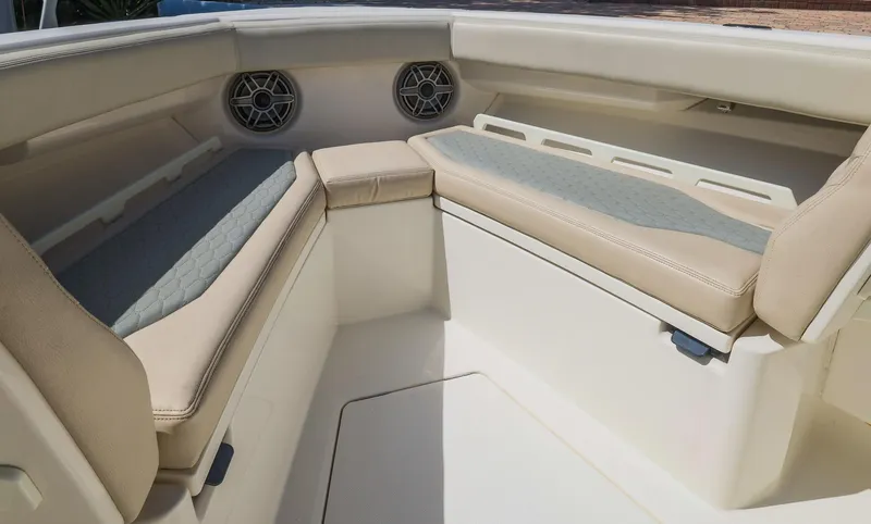 Slide: The Image of Interior seating of 2021 Solace 345 boat with beige cushions and speakers. - 3