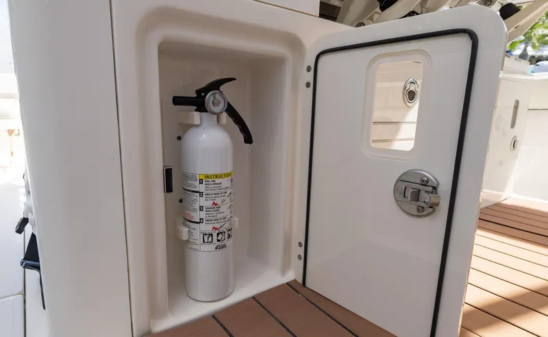 Slide: The Image of Fire extinguisher in storage compartment on 2021 Solace 345 boat deck. - 39