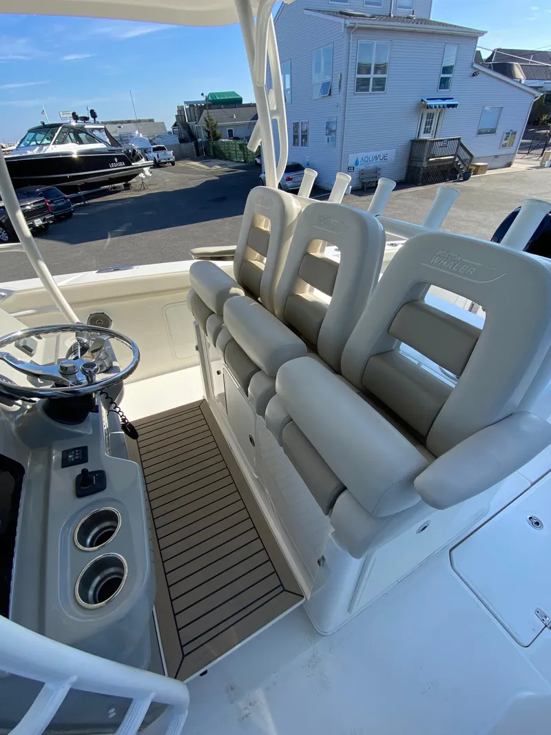 Slide: The Image of 2017 Boston Whaler 350 Outrage boat interior with cushioned seating and steering console. - 18