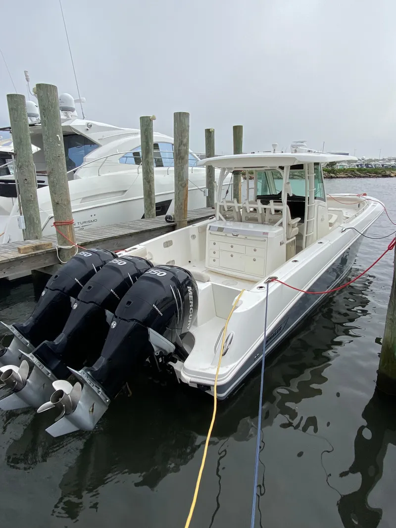 Slide: The Image of 2017 Boston Whaler 350 Outrage boat docked with triple outboard engines. - 2