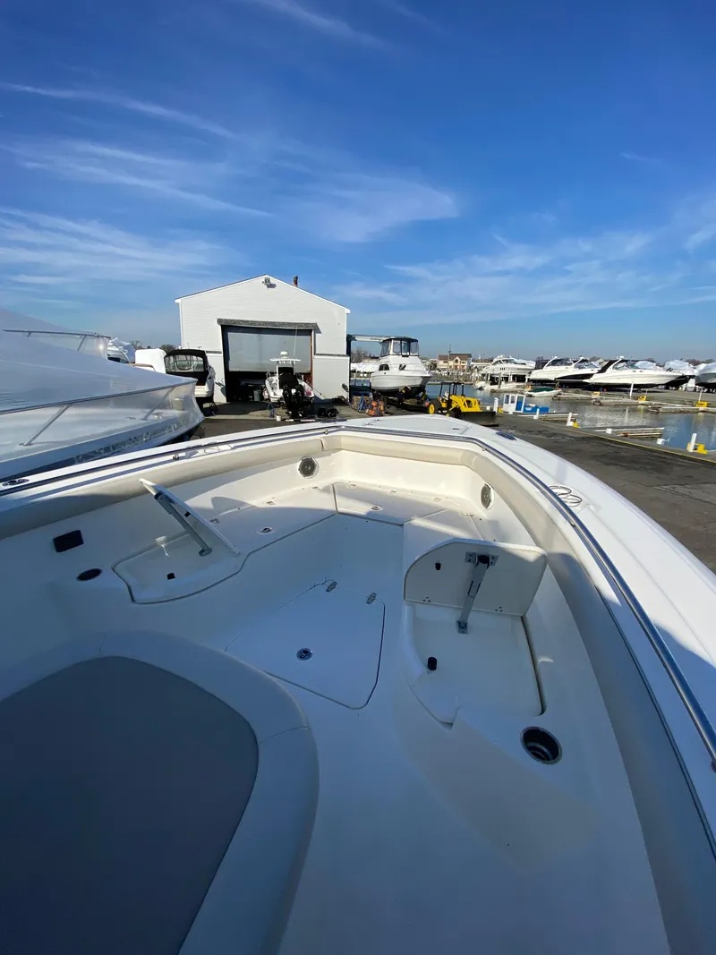 Slide: The Image of 2017 Boston Whaler 350 Outrage boat docked at a marina under a clear blue sky. - 25