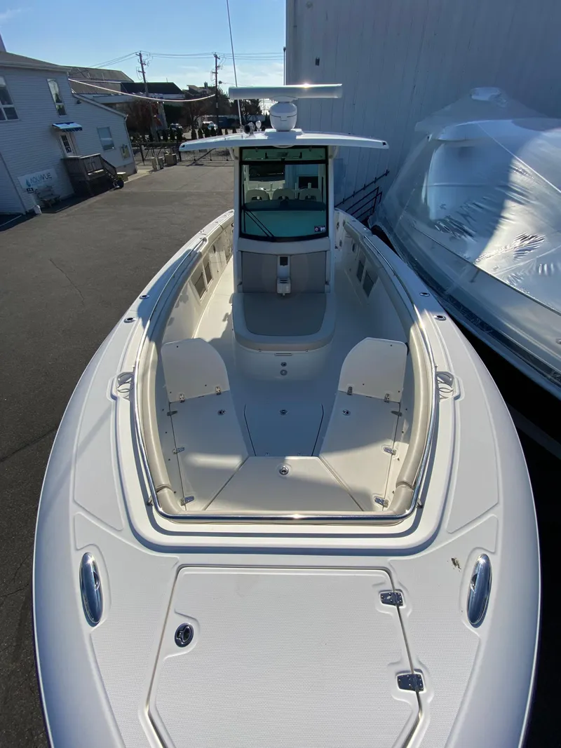 Slide: The Image of 2017 Boston Whaler 350 Outrage boat, docked, showcasing spacious deck and sleek design. - 26