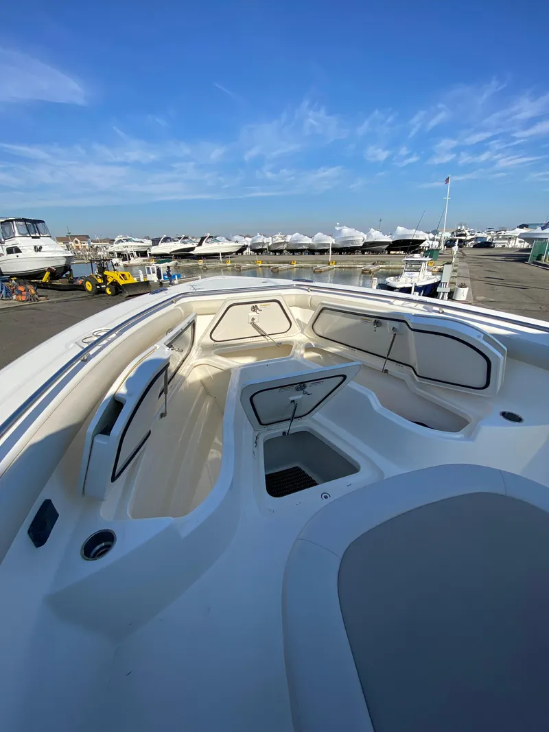 Slide: The Image of 2017 Boston Whaler 350 Outrage boat interior with seating and storage, docked under clear blue sky. - 27