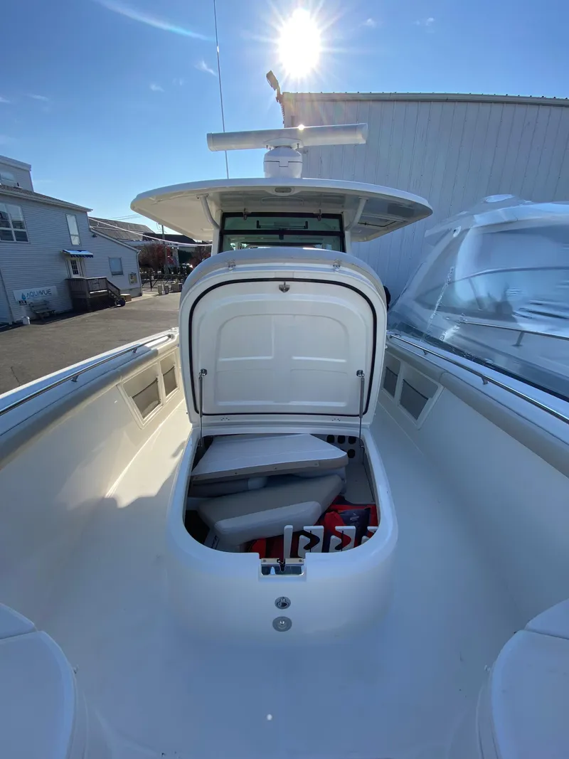 Slide: The Image of 2017 Boston Whaler 350 Outrage boat with open storage compartment under sunny sky. - 28