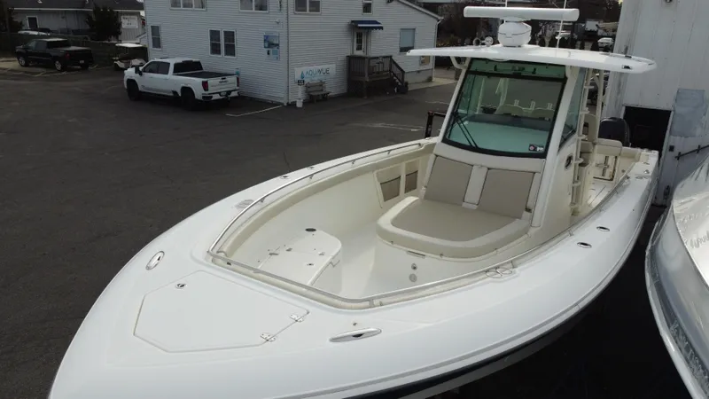 Slide: The Image of 2017 Boston Whaler 350 Outrage boat docked, showcasing sleek design and spacious deck. - 3
