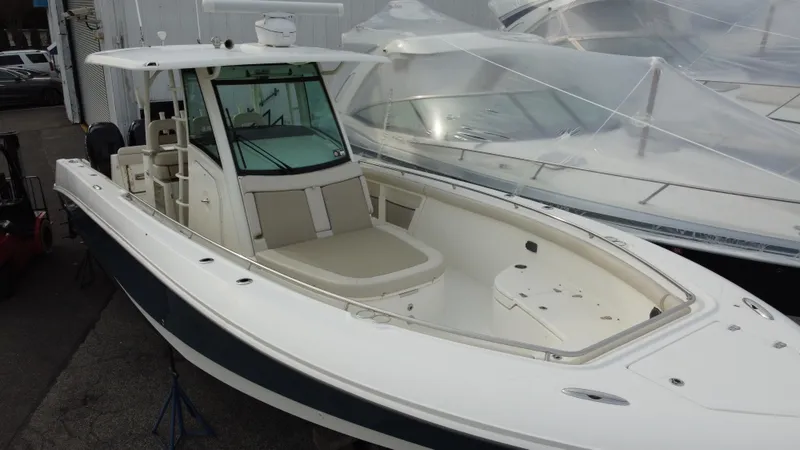 Slide: The Image of 2017 Boston Whaler 350 Outrage boat, white exterior, docked in a marina. - 4