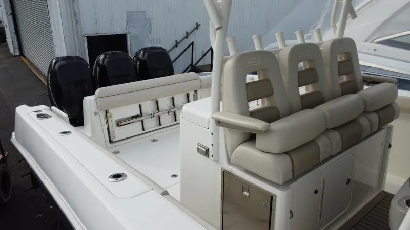 Slide: The Image of 2017 Boston Whaler 350 Outrage boat interior with seating and triple outboard engines. - 7