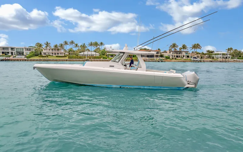 Slide: The Image of 2020 Intrepid 407 Panacea boat on clear water with palm trees in the background. - 1