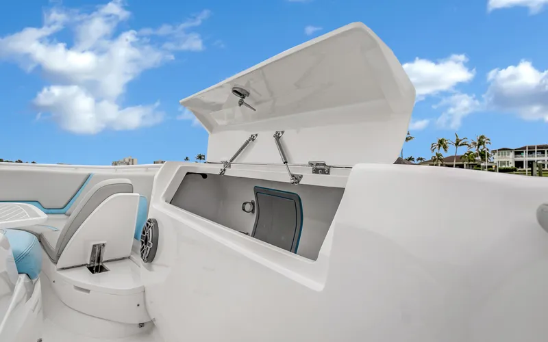 Slide: The Image of 2020 Intrepid 407 Panacea boat with open storage compartment under a clear blue sky. - 12