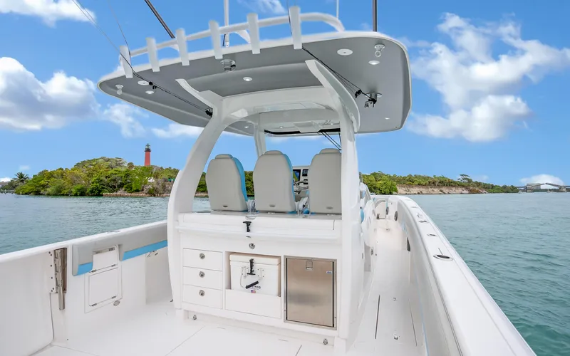 Slide: The Image of 2020 Intrepid 407 Panacea boat interior with seating and storage, cruising on a scenic waterway. - 25