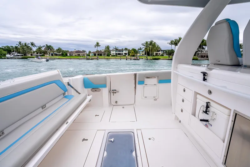 Slide: The Image of 2020 Intrepid 407 Panacea boat interior with seating and storage, near waterfront homes. - 29