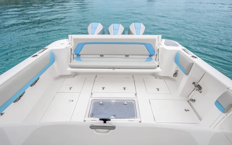 Slide: The Image of 2020 Intrepid 407 Panacea boat interior with spacious deck and seating, on clear blue water. - 31