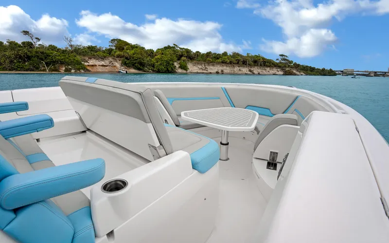 Slide: The Image of 2020 Intrepid 407 Panacea boat interior with seating and table, on calm water. - 9
