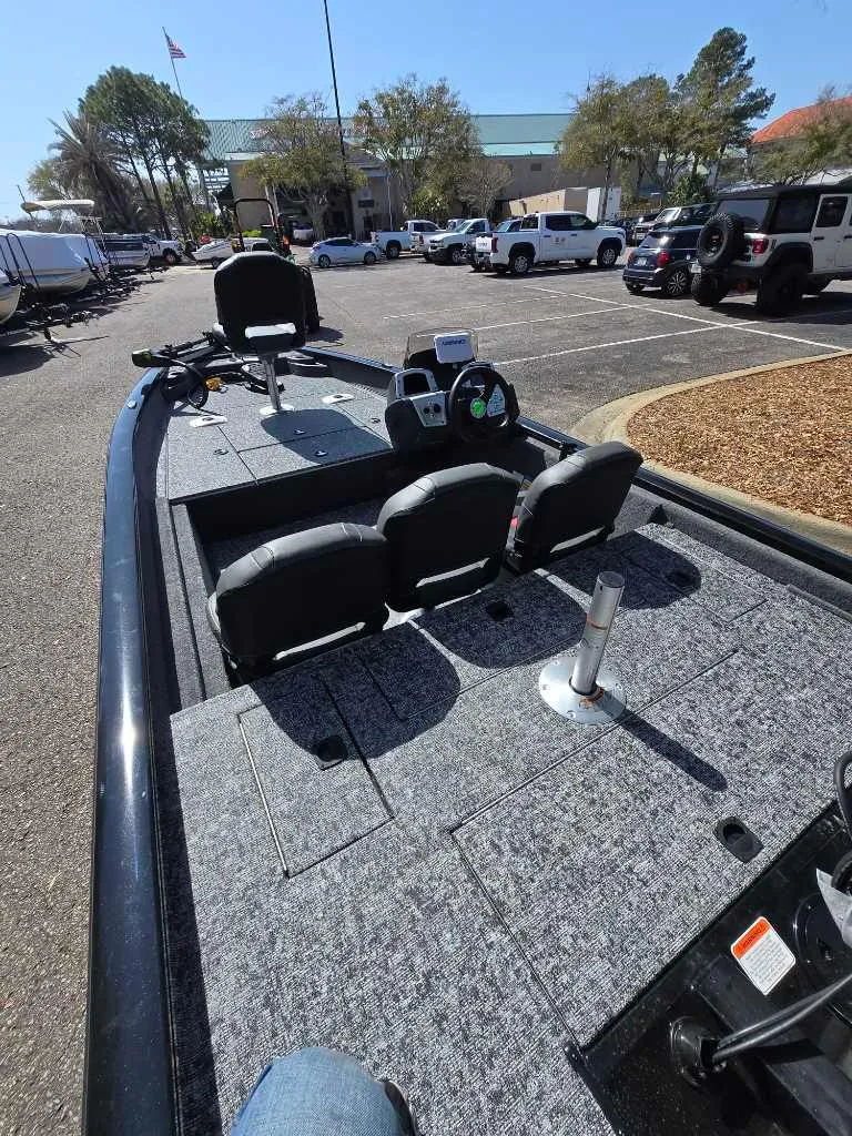 Slide: The Image of 2025 Tracker Pro Team 175 Crappie Edition boat with seating, parked in a lot. - 2