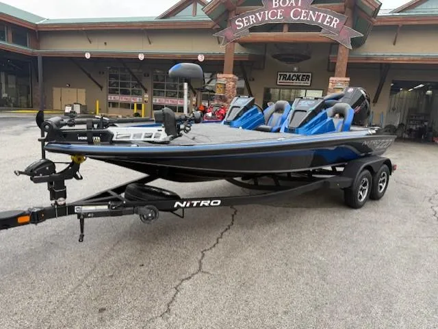 Slide: The Image of 2025 Nitro Z20 XL Pro boat at service center, sleek design, dual seats, trailer attached. - 1