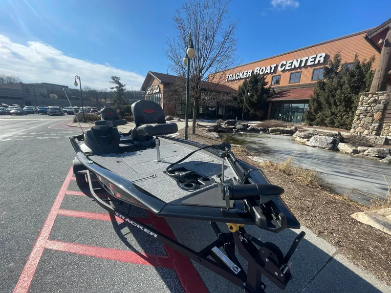 Slide: The Image of 2025 Tracker Pro Team 190 boat outside Tracker Boat Center on a sunny day. - 2