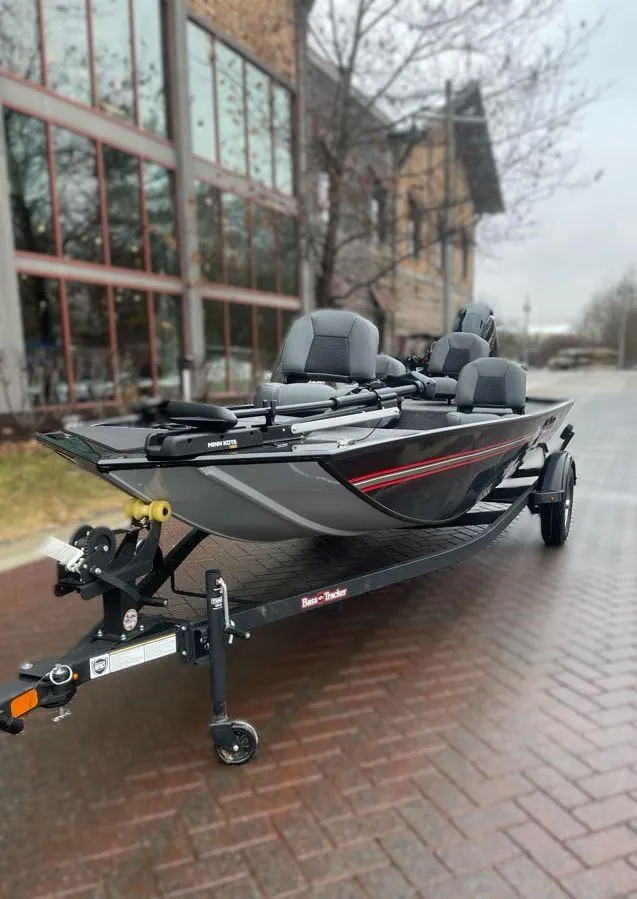 Slide: The Image of 2025 Tracker Bass Tracker Classic XL boat on a trailer, parked on a brick path. - 2