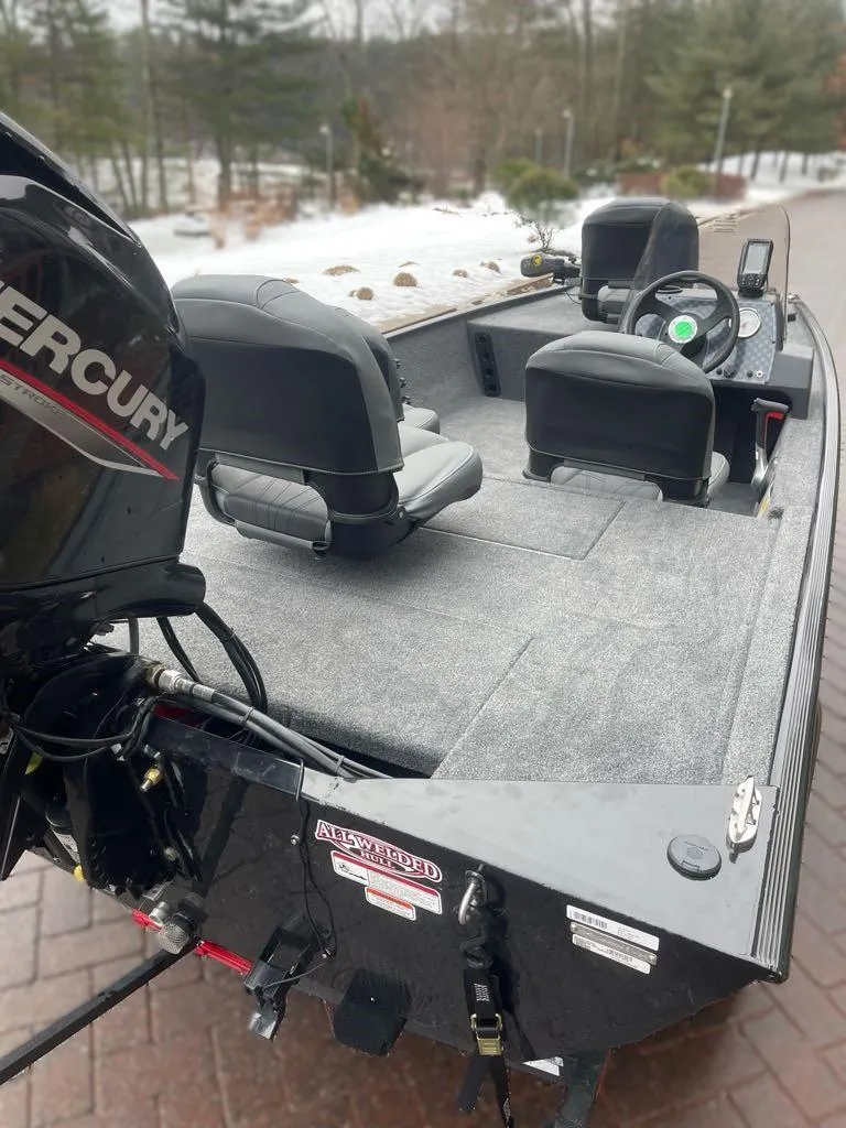 Slide: The Image of 2025 Tracker Bass Tracker Classic XL boat with Mercury engine, parked on a brick driveway. - 5