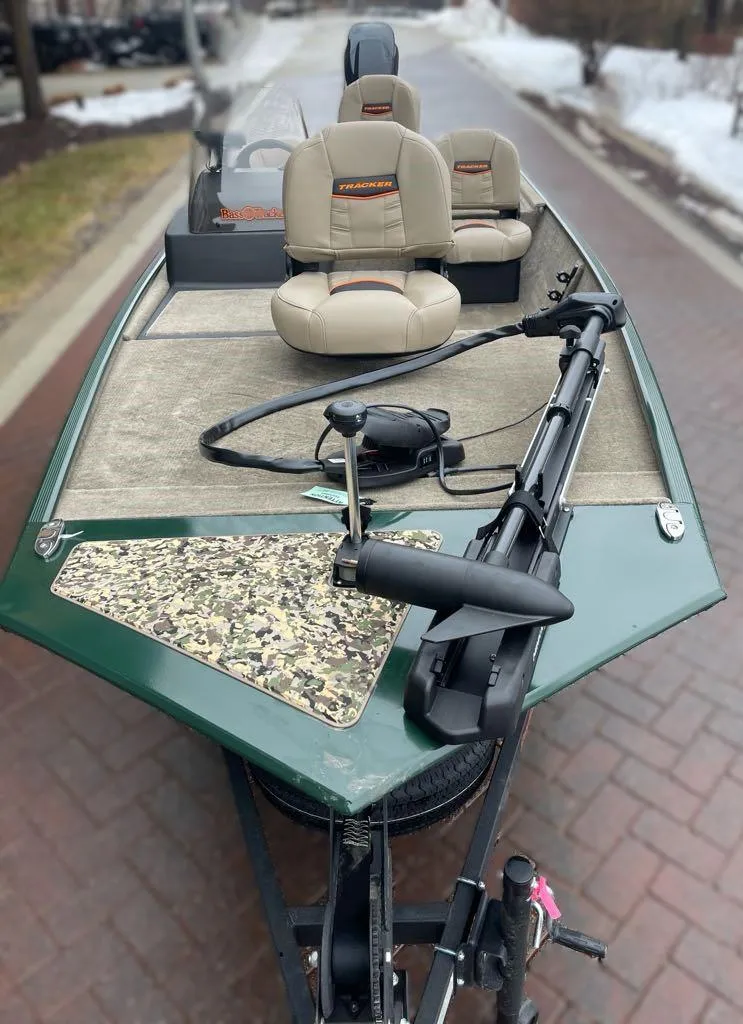 Slide: The Image of 2025 Tracker Bass Tracker Classic Limited boat with seating and trolling motor on a paved road. - 2