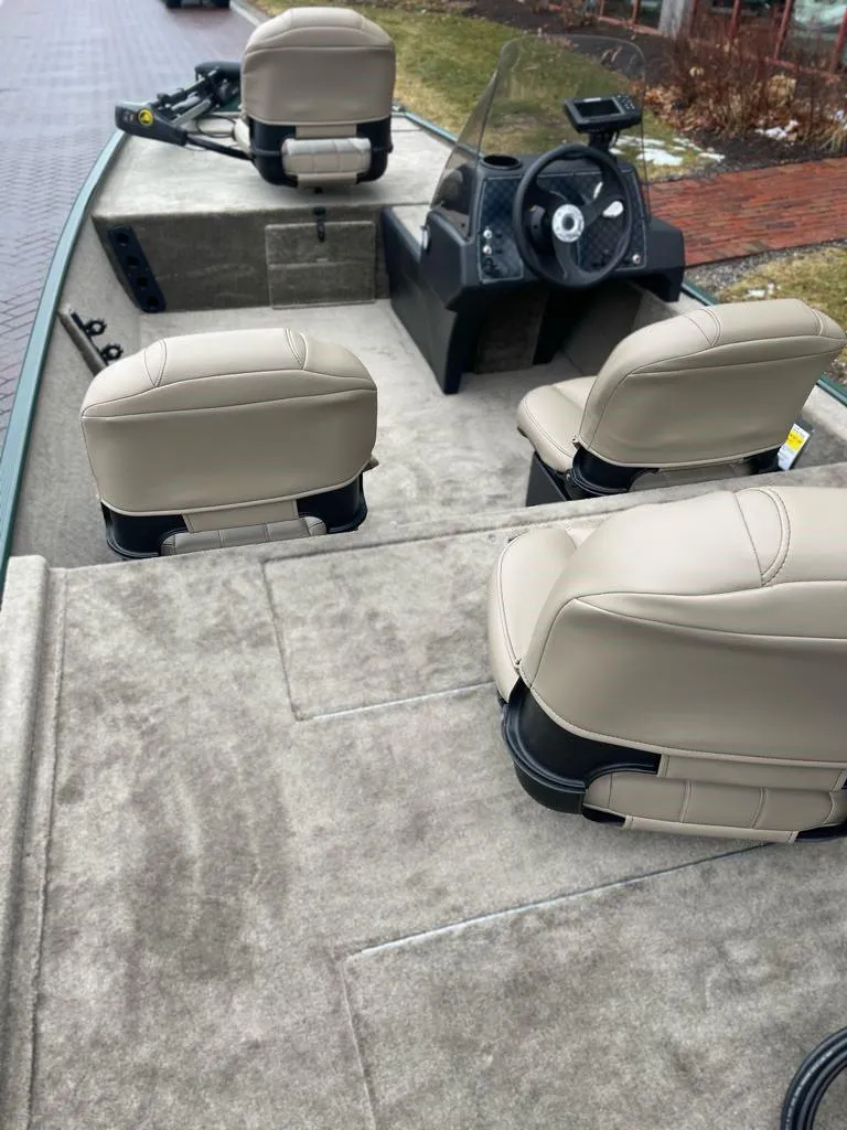 Slide: The Image of 2025 Tracker Bass Tracker Classic Limited boat interior with beige seats and steering console. - 3