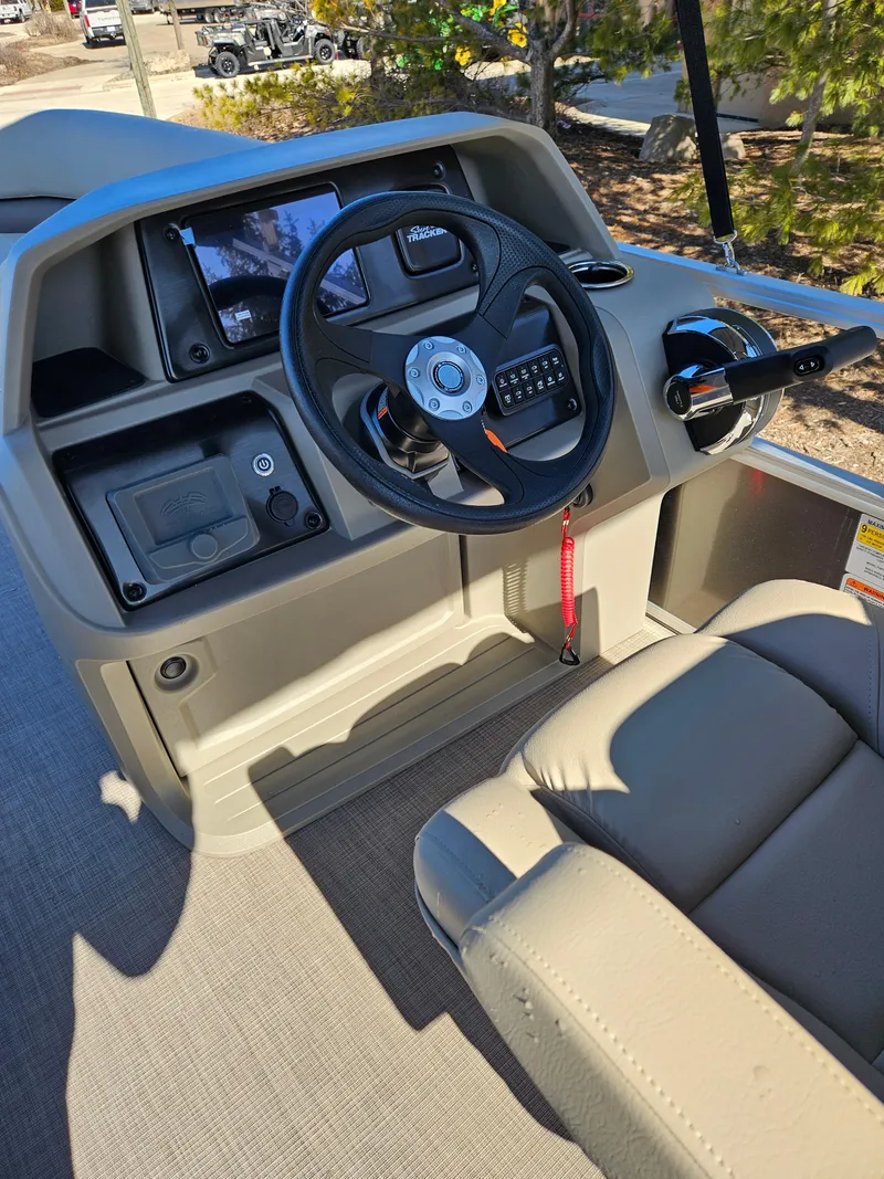 Slide: The Image of 2025 Sun Tracker Party Barge 18 DLX helm with steering wheel and control panel. - 2