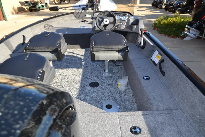 Slide: The Image of 2025 Tracker Pro Guide V-16 SC boat interior with seating and steering console. - 2