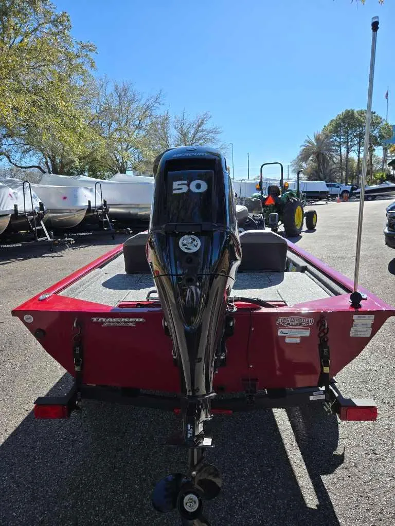 Slide: The Image of 2025 Tracker Pro 170 boat with 50 HP engine, parked outdoors. - 2