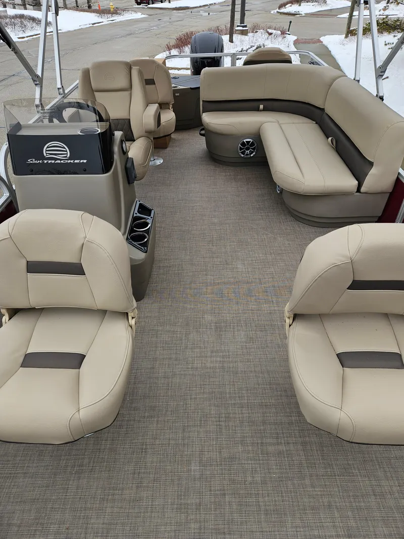 Slide: The Image of 2025 Sun Tracker Bass Buggy 18 DLX interior with beige seating and spacious layout. - 2