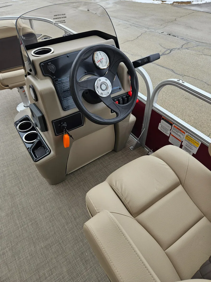 Slide: The Image of 2025 Sun Tracker Bass Buggy 18 DLX boat interior with steering wheel and seating. - 3