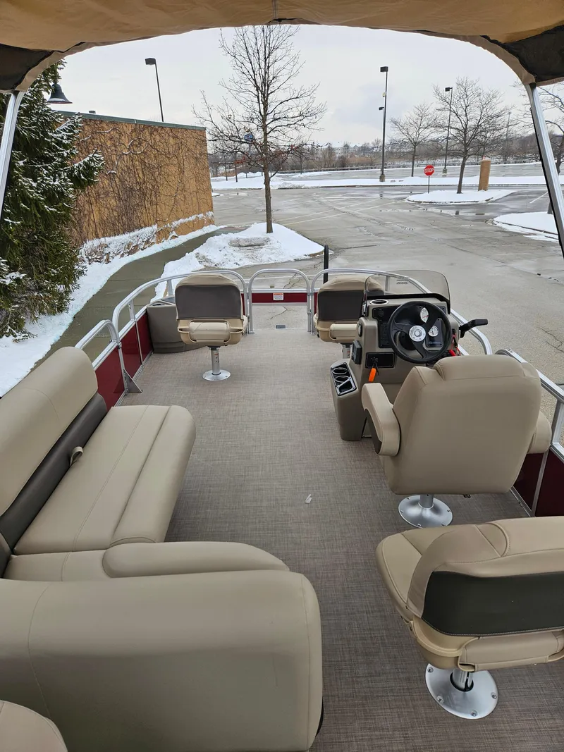 Slide: The Image of 2025 Sun Tracker Bass Buggy 18 DLX pontoon boat with beige seating in snowy parking lot. - 4