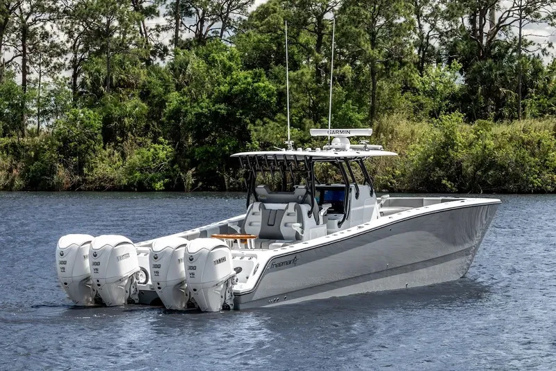 The Image of 2025 Freeman 38 boat with four engines on a calm river, surrounded by trees. - 1