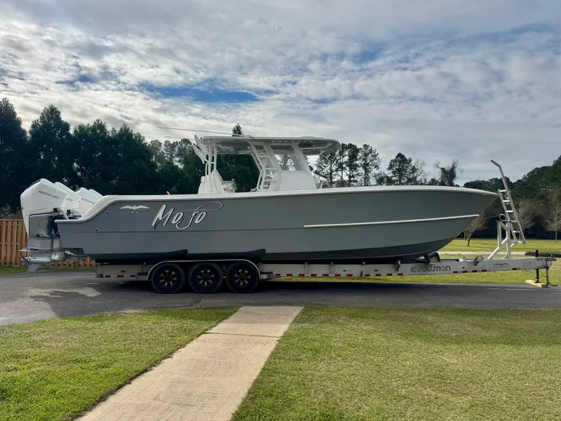 The Image of 2022 Invincible 35 Catamaran on trailer, parked outdoors with cloudy sky backdrop. - 1