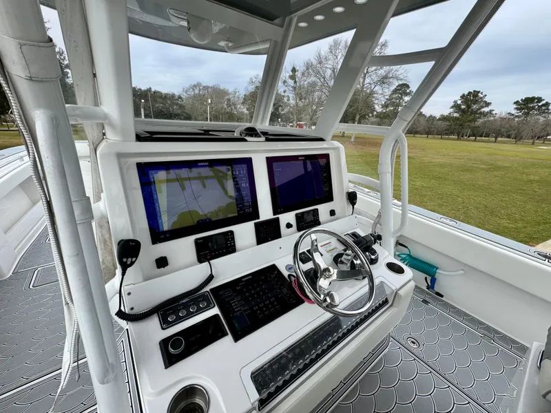 Slide: The Image of 2022 Invincible 35 Catamaran helm with dual navigation screens and steering wheel. - 14