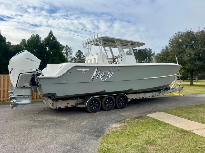 Slide: The Image of 2022 Invincible 35 Catamaran on trailer, parked outdoors, featuring sleek design and twin engines. - 3