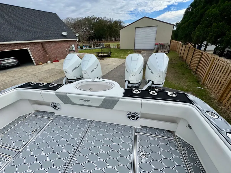 Slide: The Image of 2022 Invincible 35 Catamaran with triple outboard engines, parked in a residential driveway. - 7