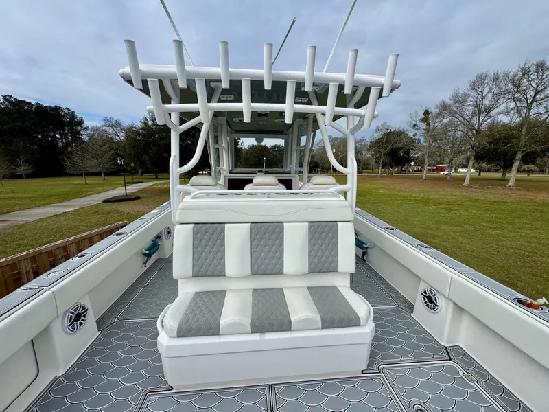 Slide: The Image of 2022 Invincible 35 Catamaran with cushioned seating and rod holders, set in a grassy area. - 8