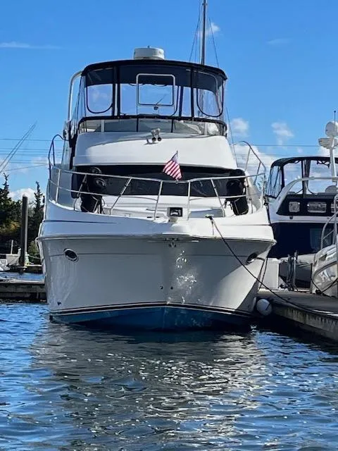 Slide: The Image of 2004 Silverton 39 Motor Yacht docked in a marina under a clear blue sky. - 2