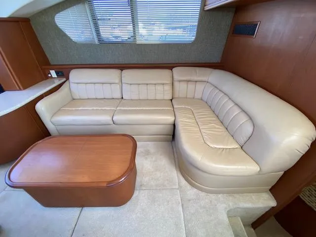 Slide: The Image of 2004 Silverton 39 Motor Yacht interior with beige leather sofa and wooden table. - 5