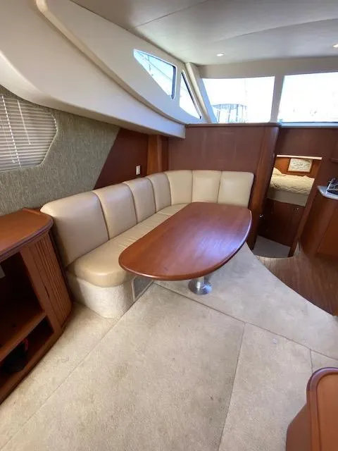 Slide: The Image of 2004 Silverton 39 Motor Yacht interior with beige seating and wooden table. - 6
