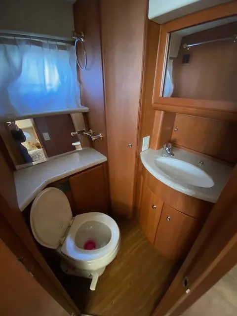 Slide: The Image of 2004 Silverton 39 Motor Yacht bathroom with wooden cabinetry, sink, and toilet. - 9