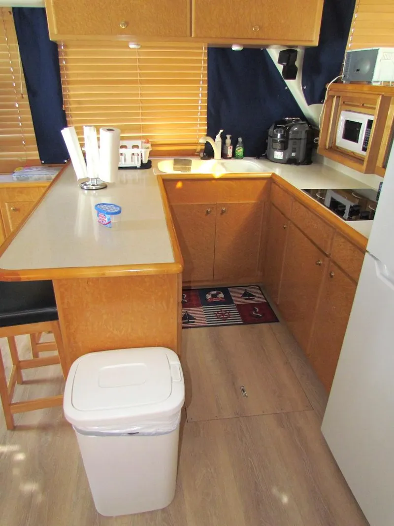 Slide: The Image of 1998 Navigator 53 kitchen interior with wooden cabinets, countertop, and appliances. - 15