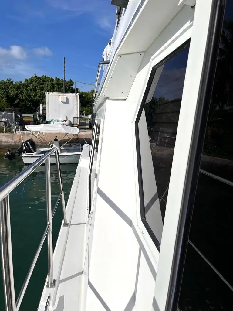Slide: The Image of 1998 Navigator 53 yacht side view, docked, with clear skies and calm waters. - 8
